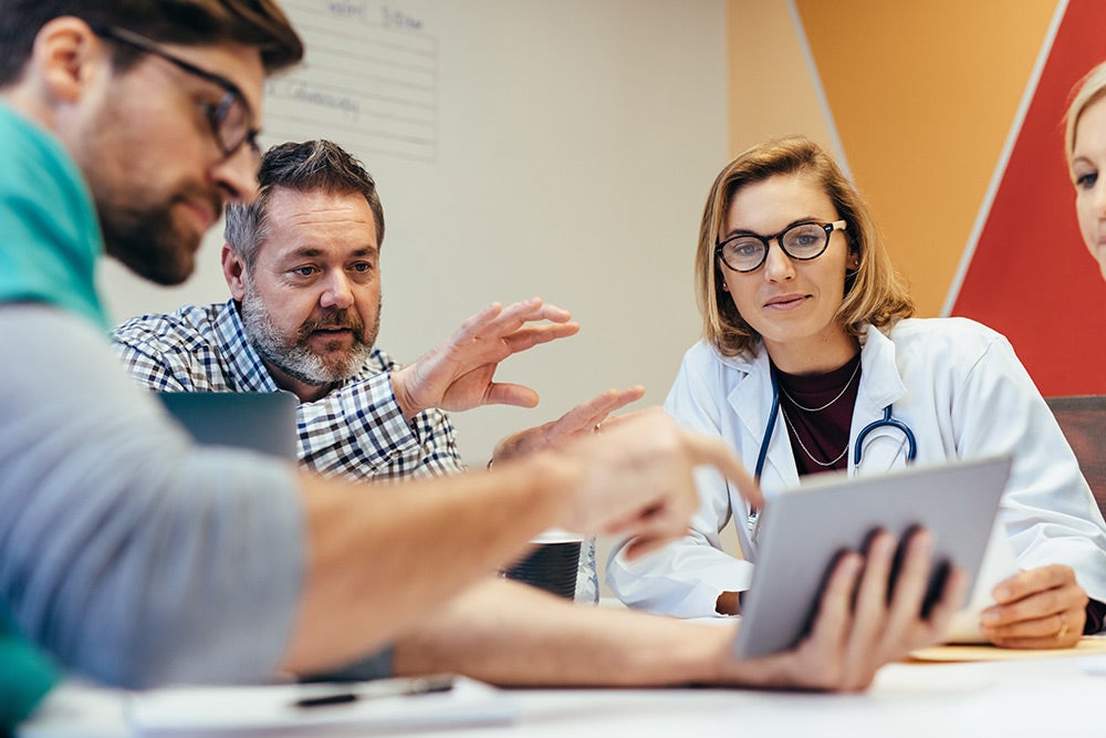 Healthcare professionals in a conference room reviewing data