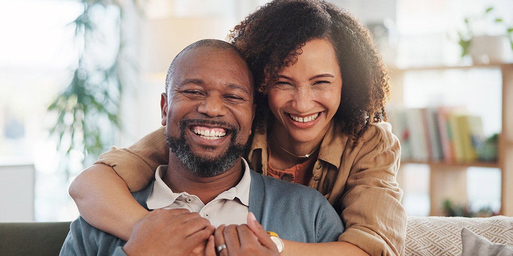 family members hugging and smiling on the couch