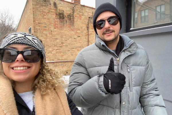 David haciendo el gesto del pulgar hacia arriba y su novia fuera en invierno