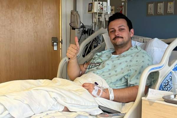 David, en la cama del hospital, levantando el pulgar en señal de aprobación