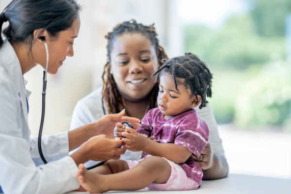 Mother holding baby grabbing doctor's stethoscope