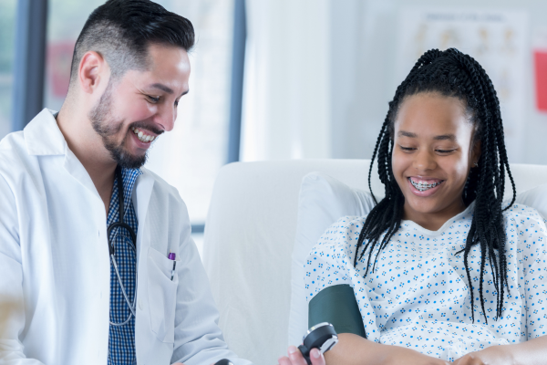 Younger patient looking at blood pressure with doctor
