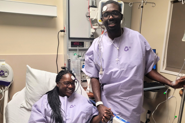 Kamri in hospital bed holding Latonna's hand