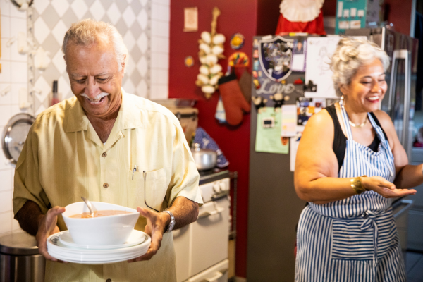 Two older adults happily cooking