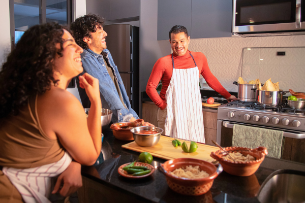 Two people laughing with person cooking