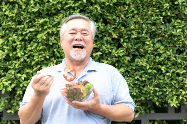 Person happily eating a salad outside