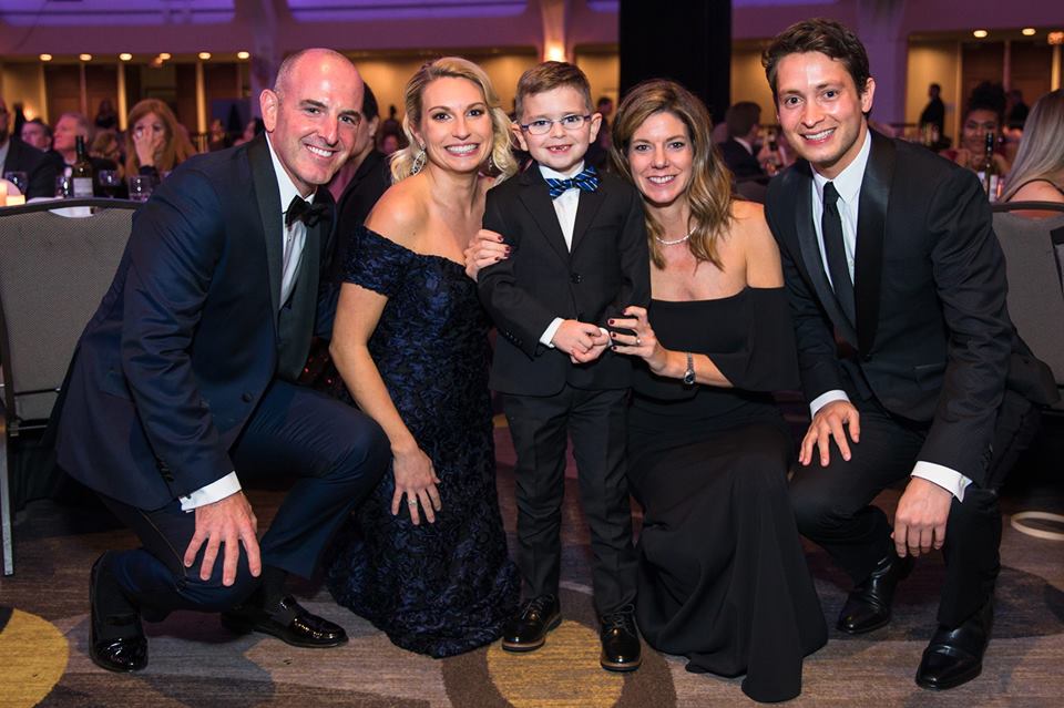 a group of four people standing together in formal dress at the Kidney Ball