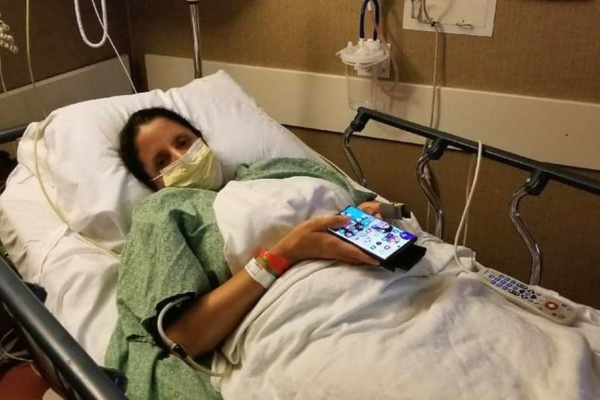 Abby Jimenez in hospital bed with mask on