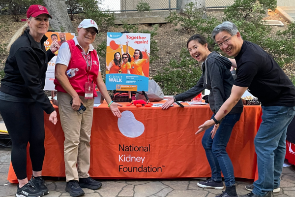 Amy and Wilson's family pointing at NKF booth