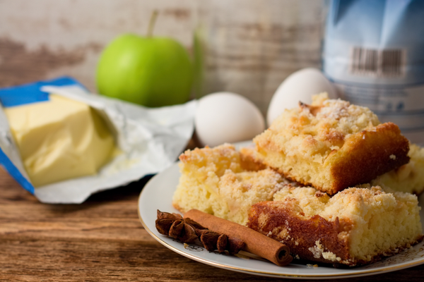 Plate of apple cake with ingredients behind it