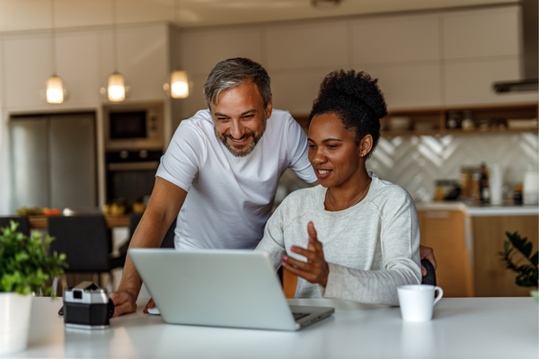 Two people in kitchen looking at the computer