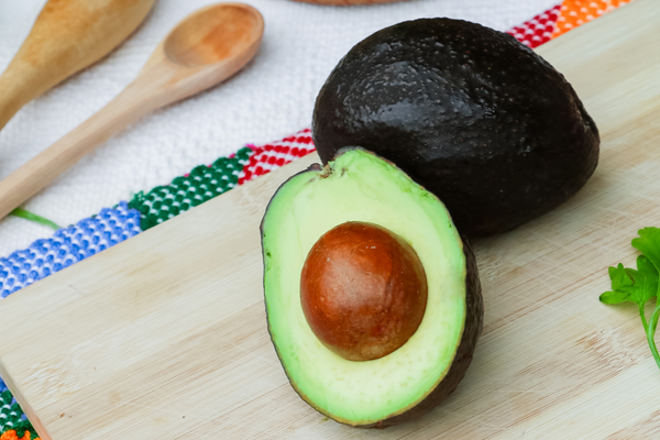 Halved avocado on cutting board 