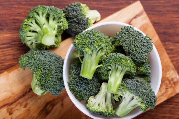 Bowls of broccoli on wood cutting board