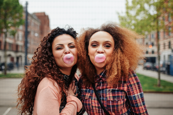 Two people with bubble gum bubbles