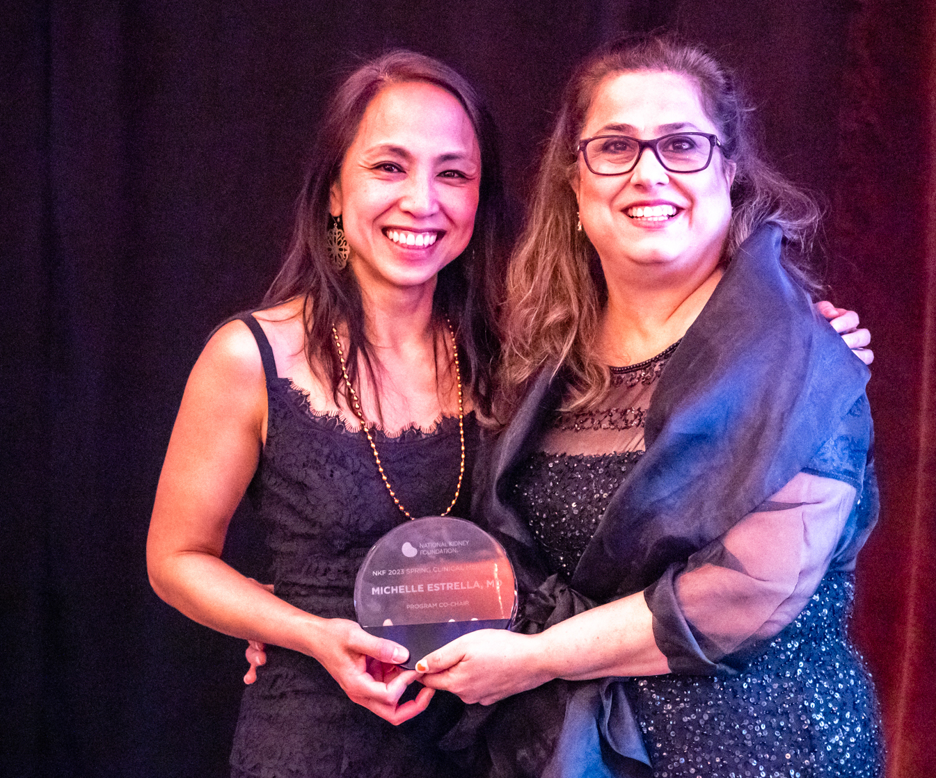 Two Women holding an award at SCM23