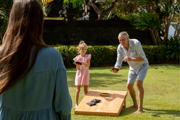 Grandparent and child happily playing cornhole