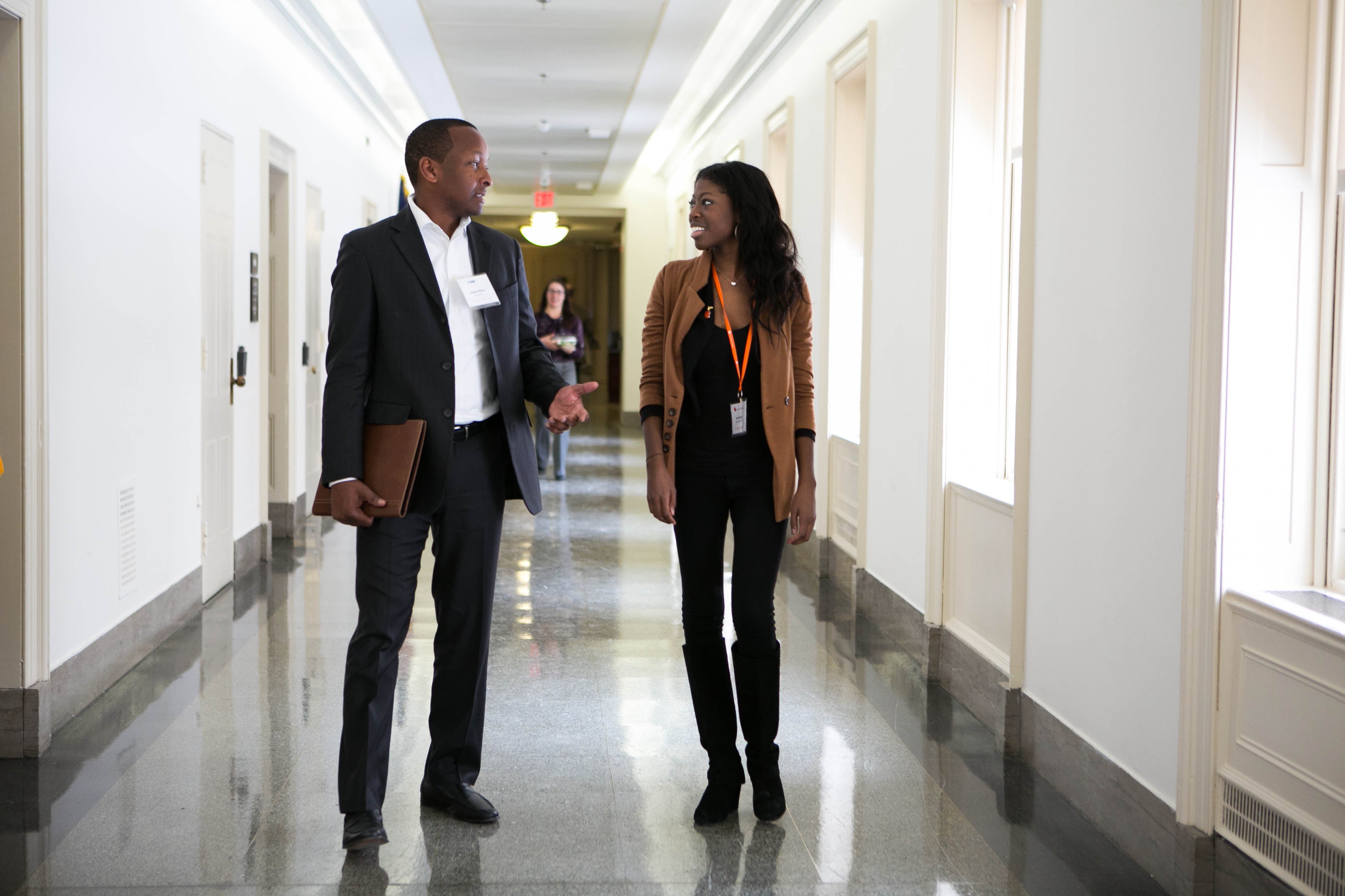 two professionals discussing in a hallway, one wearing National Kidney Foundation swag