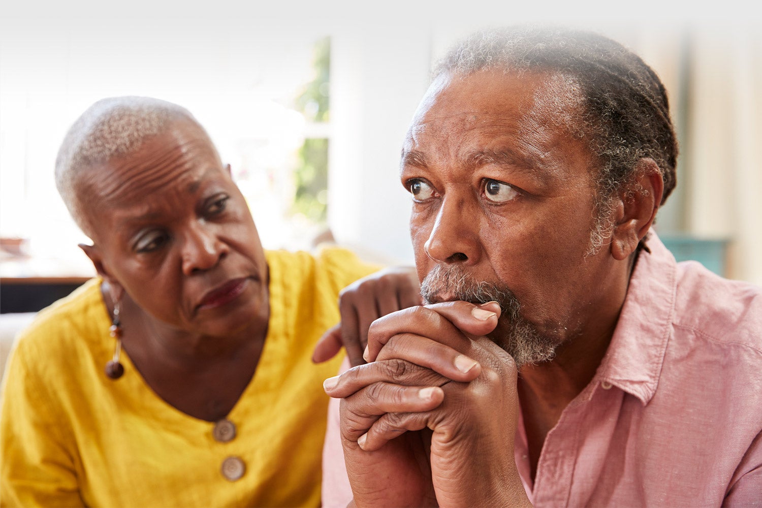 Man looking concerned and a woman is comforting him