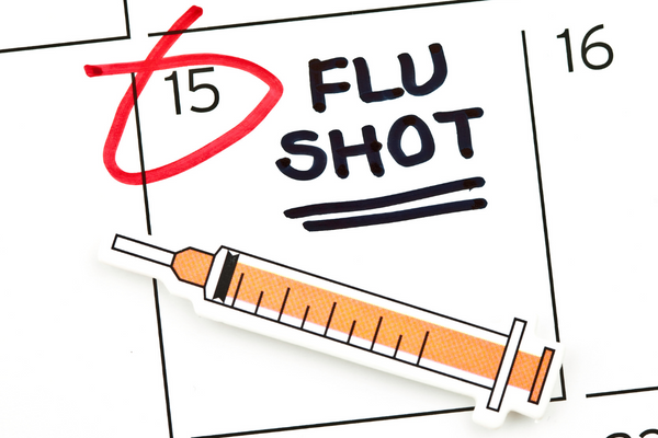 Date in calendar circled for flu shot with paper vaccine cut out