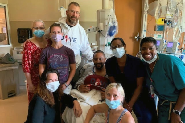 Veteran Jon Damon in hospital surrounded by DOVE volunteers