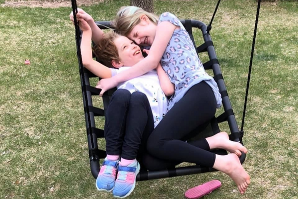 Ellie and Emma giggling on a swing