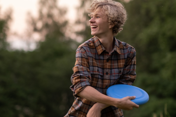 Person throwing a frisbee with smile on their face