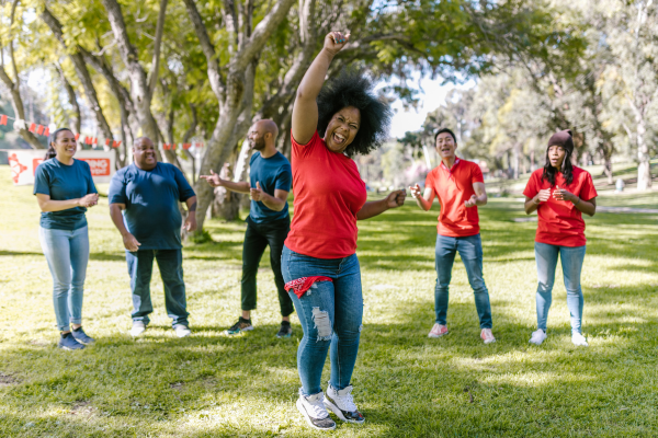 People happily dancing in park