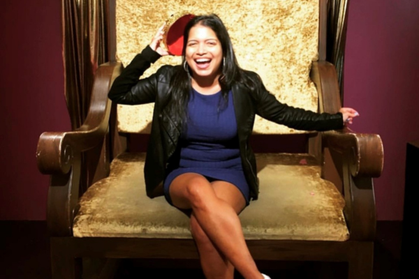 Isha Triguero smiling on large chair