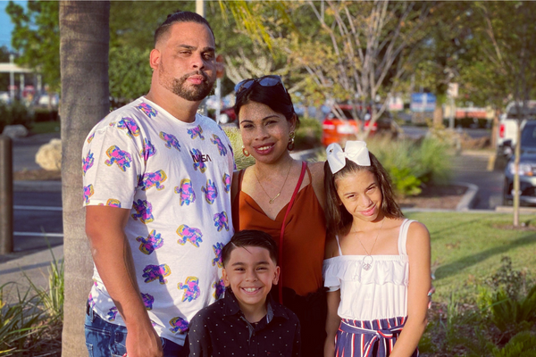 Jessica, her husband, and children smiling outside