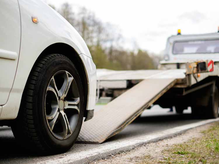 Close-up of a car driving onto a tow truck