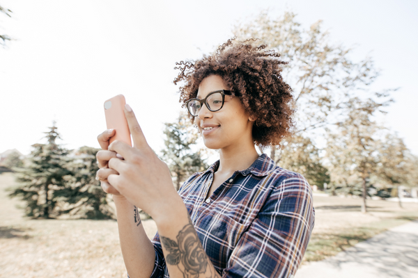 Person with rose tattoo on phone outside