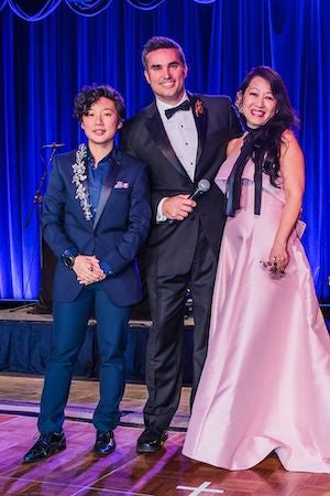 a group of four people standing together in formal dress at the Kidney Ball