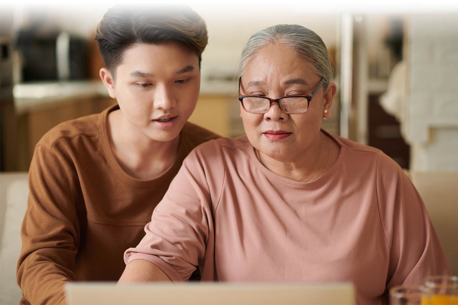 Grandmother and grandson looking at a computer together