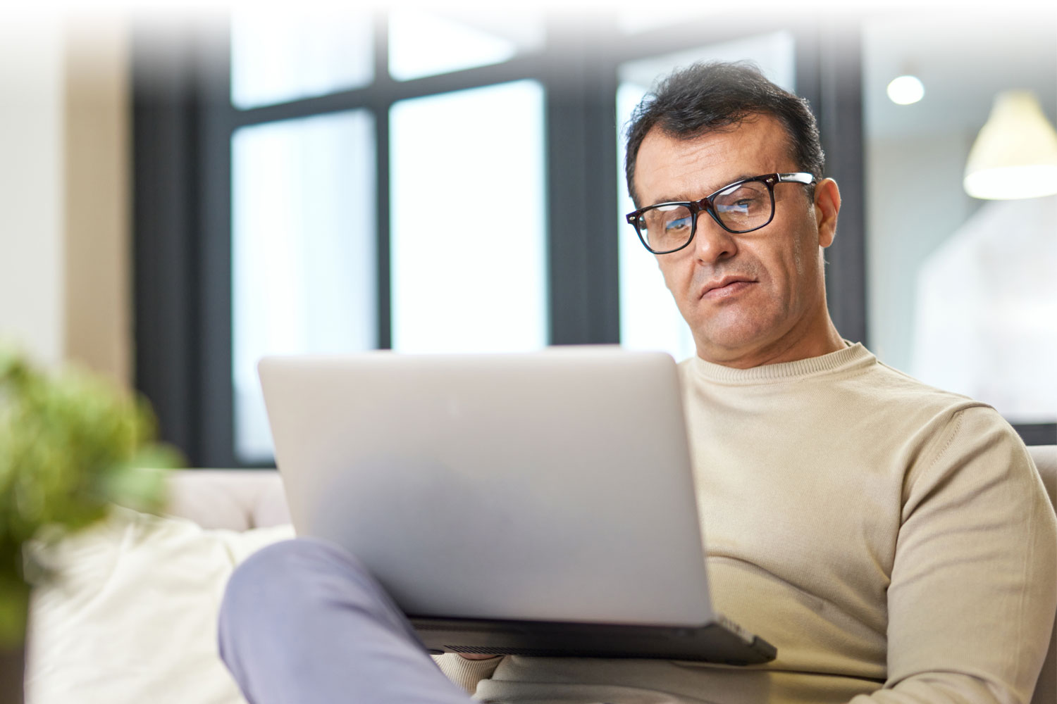 Man looking at a laptop on the couch