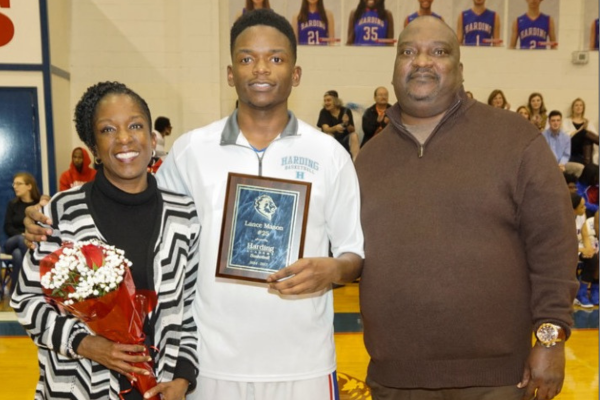 Lance Mason with a high school award in between his mother and father