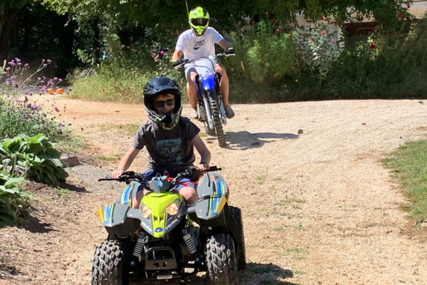 Logan on a quad and his father on a motorcycle