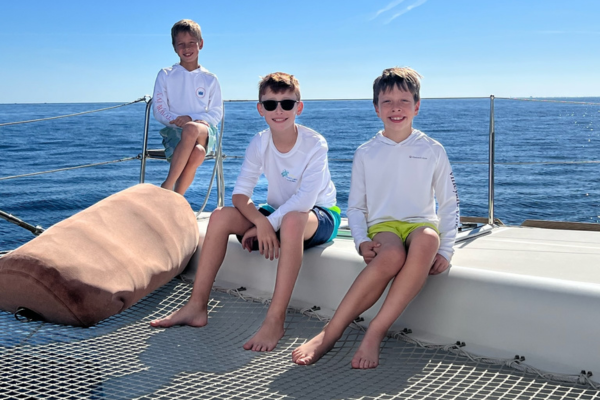 Logan on a boat by his siblings