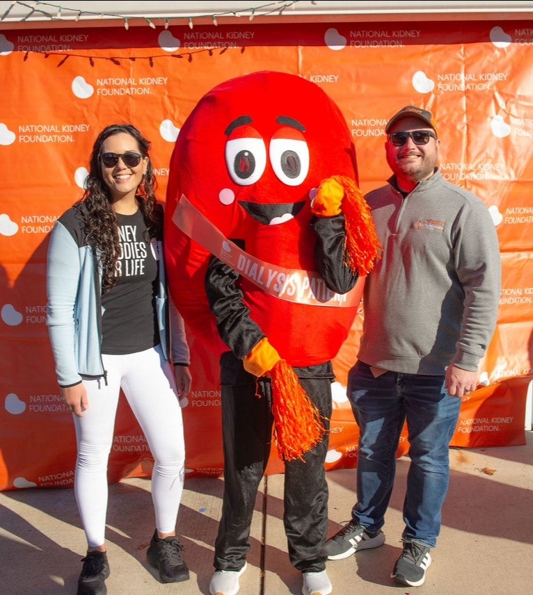 Kidney donor Jacqui and recipient Matt Hall standing with Sydney the Kidney