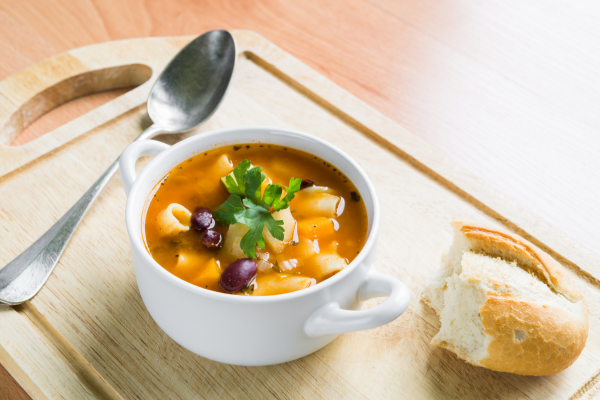 Bowl of minestrone soup on a cutting board
