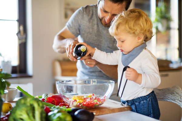 Parent and child adding oil to dish