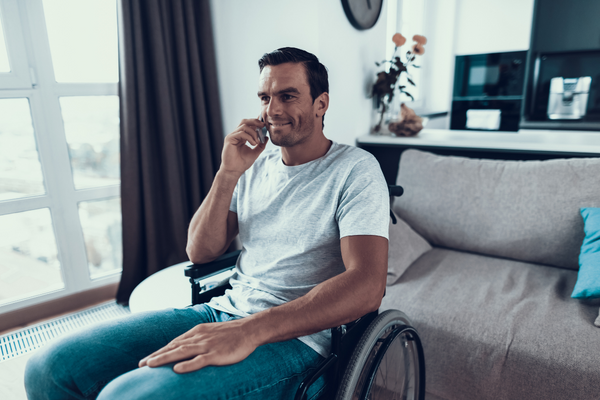 Person in wheelchair talking on the phone with slight smile