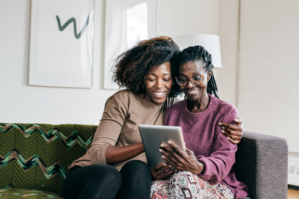 Parent and adult child looking on tablet together