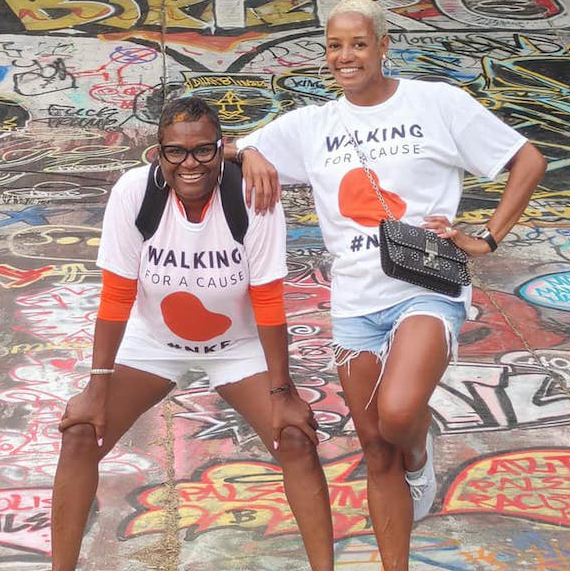 Two kidney walkers posing in front of a graffiti wall