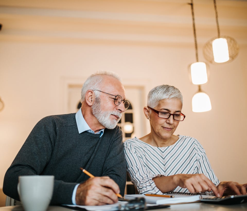 Two people working on financial documents together at a table