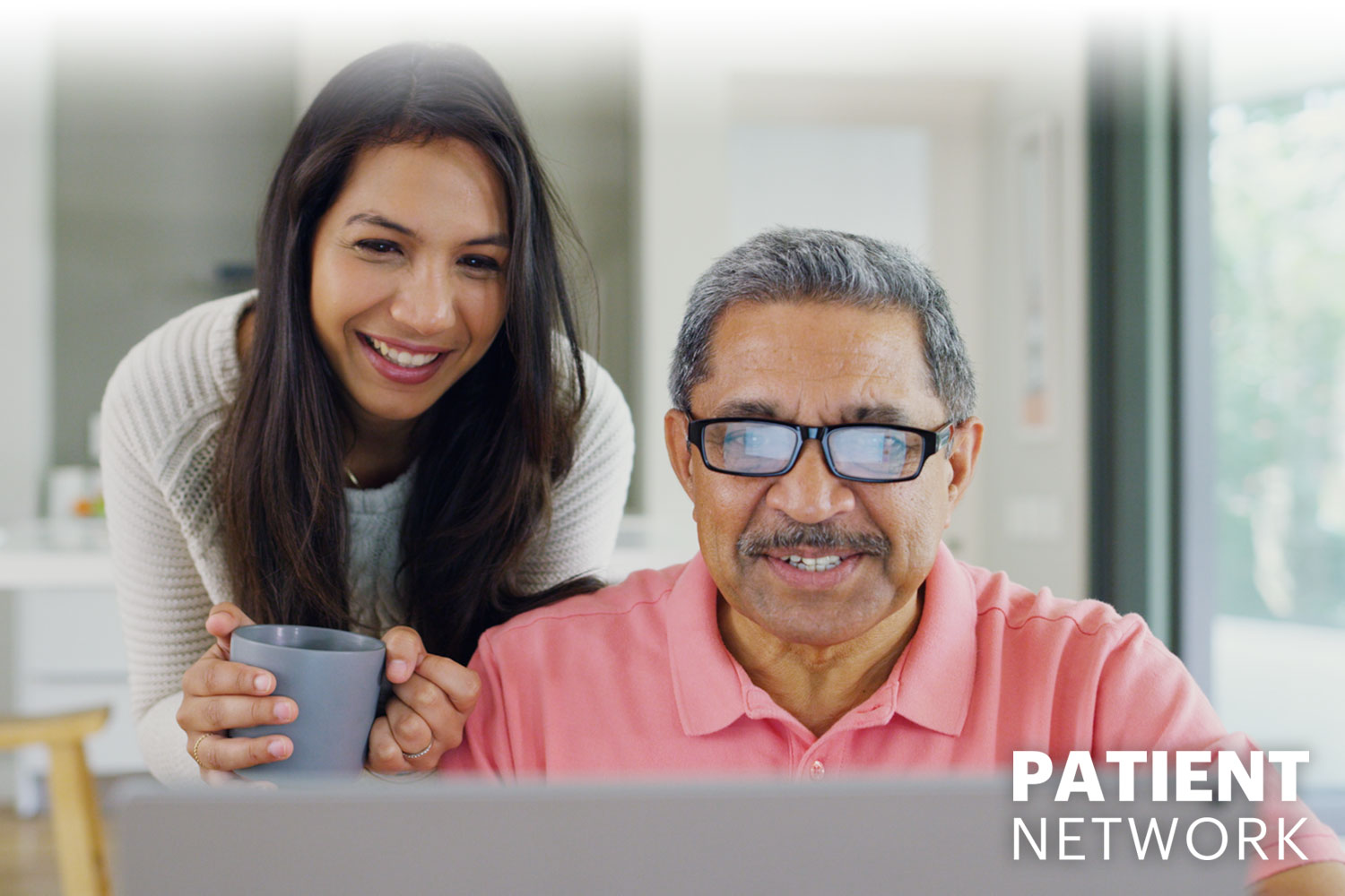 daughter encouraging her father while he looks at a laptop, Patient Network logo