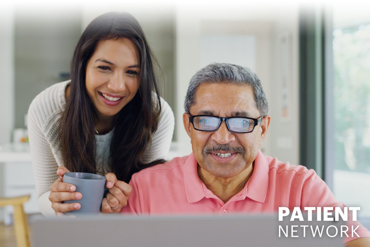 daughter encouraging her father while he looks at a laptop, Patient Network logo