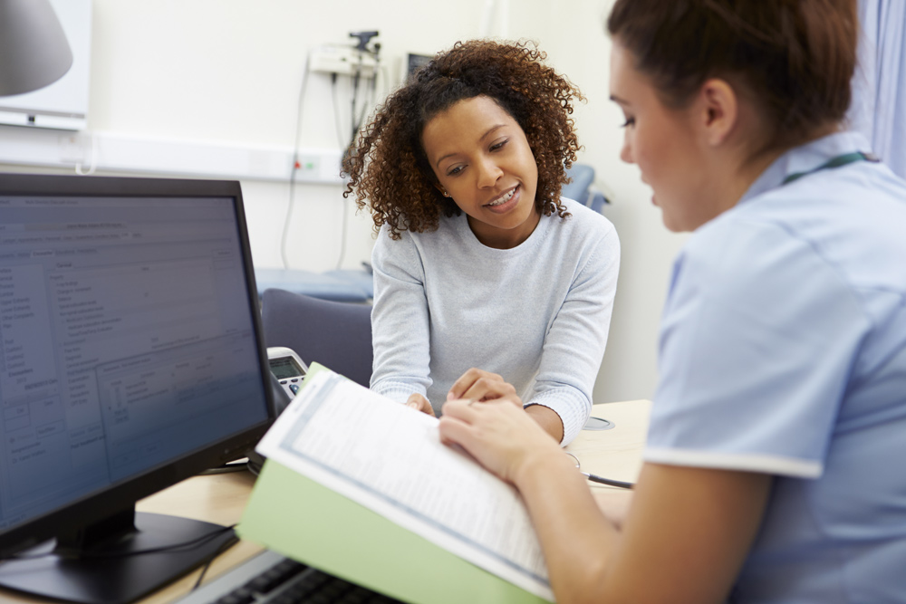 Healthcare professional going over forms with a patient in an office