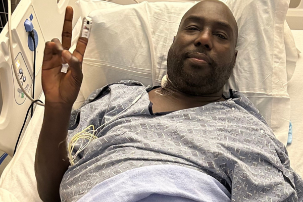 Dione giving a peace sign after transplant surgery