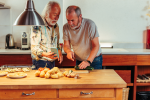Two older adults cooking together