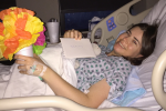 Lindsay smiling with handmade gift from Denis after surgery
